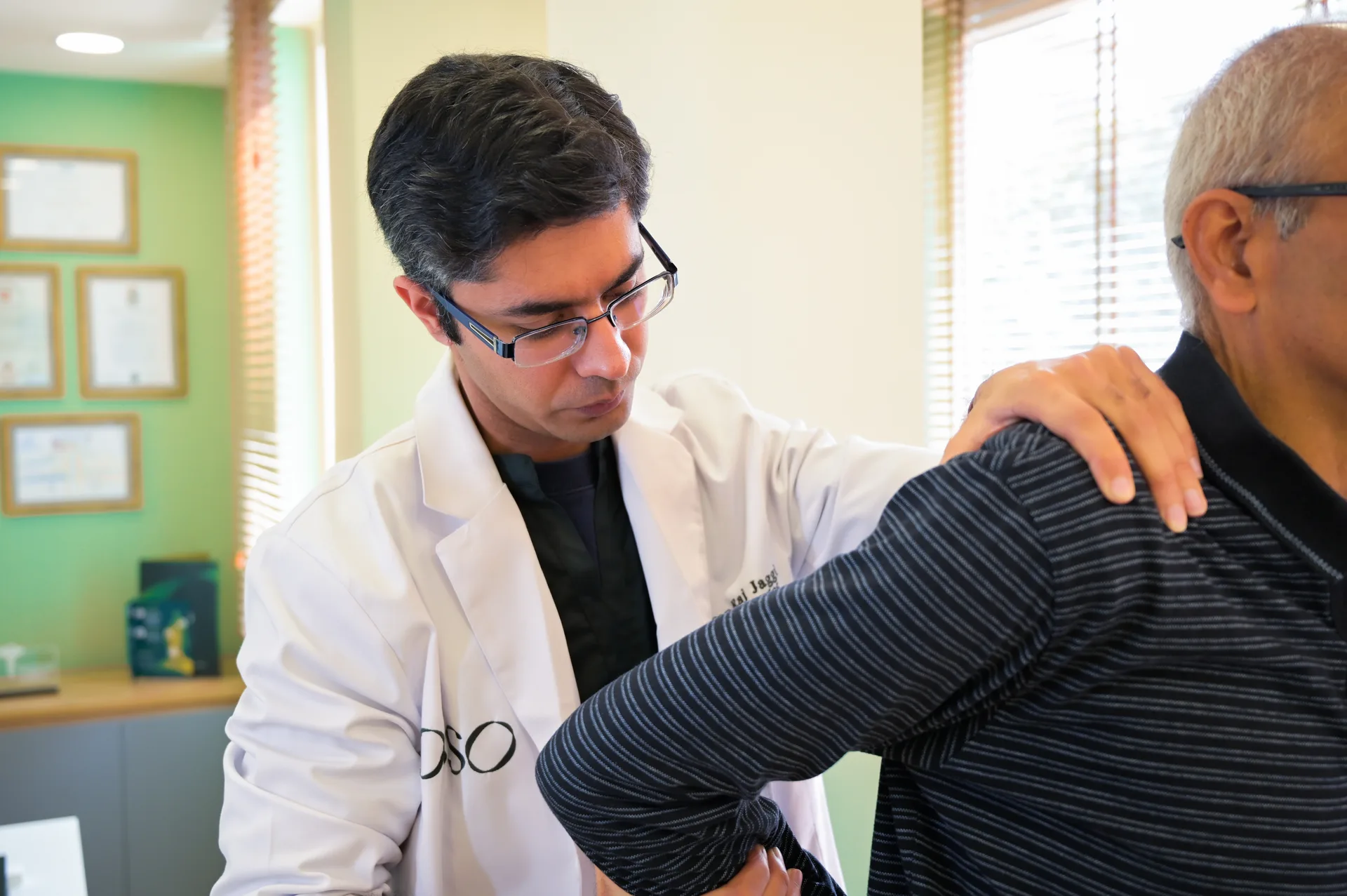 Dr. Karan Raj Jaggi explaining a knee model during a consultation